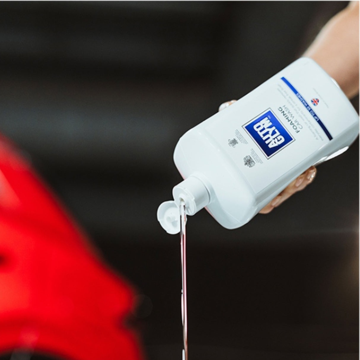 Hånd hælder Autoglym Foaming Car Wash Shampoo ud af flasken