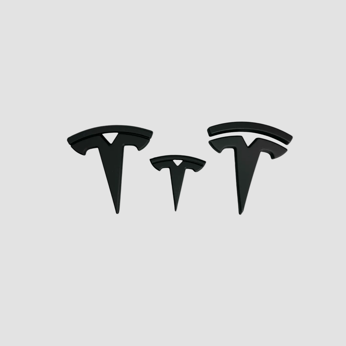 Tre sorte Tesla T-emblemer i forskellige størrelser til Tesla Model S