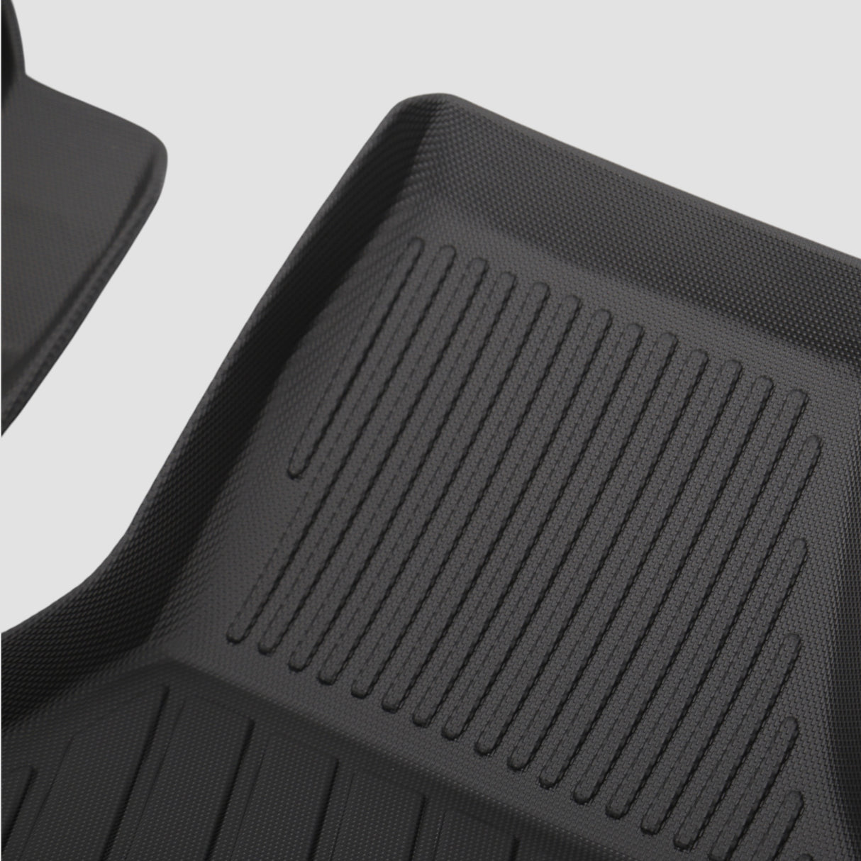Detaljer af sort 3D All Weather måttesæt med riller til bilens bagagerum.