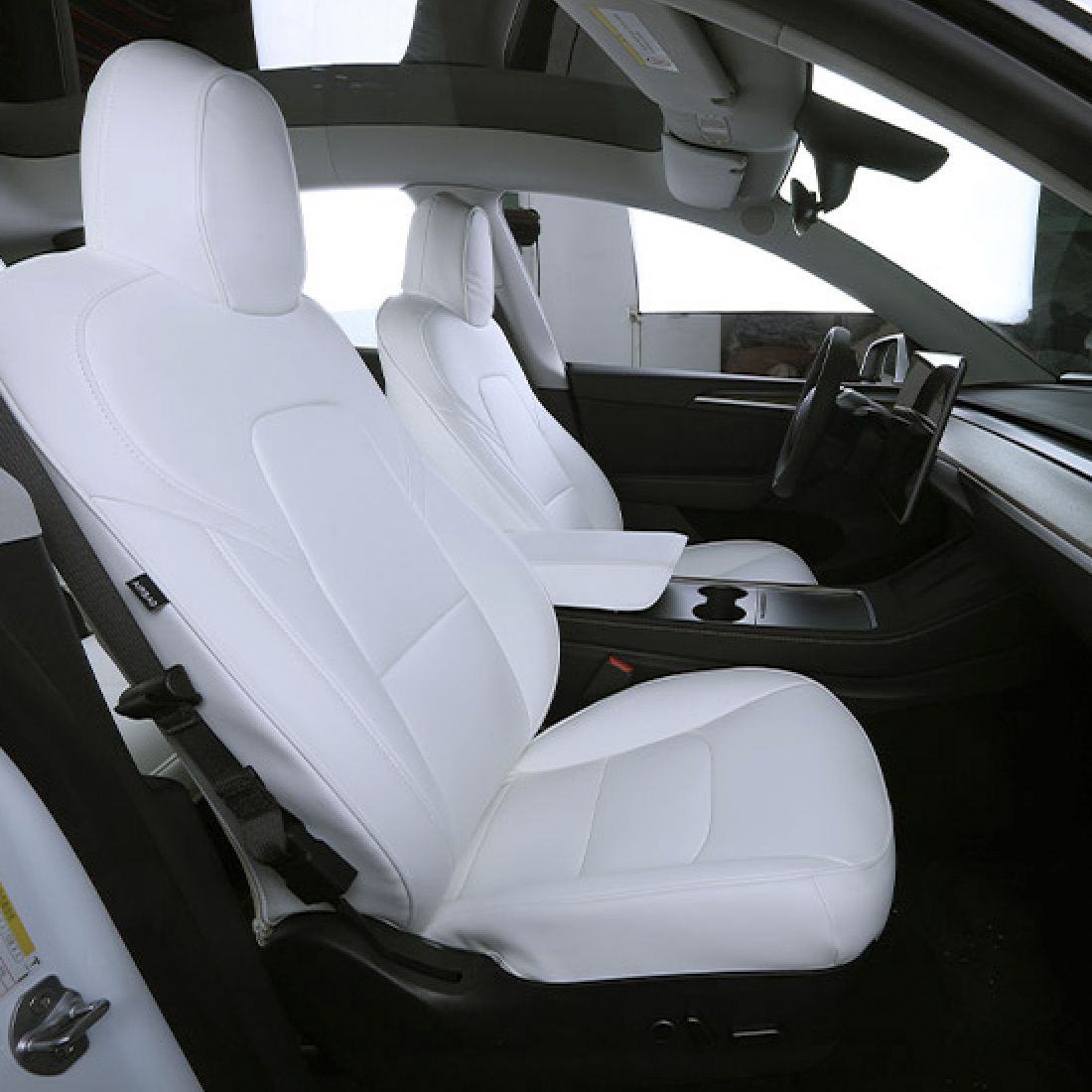 Hvide læder-sædeovertræk monteret på forsæderne i en Tesla Model Y, set fra siden