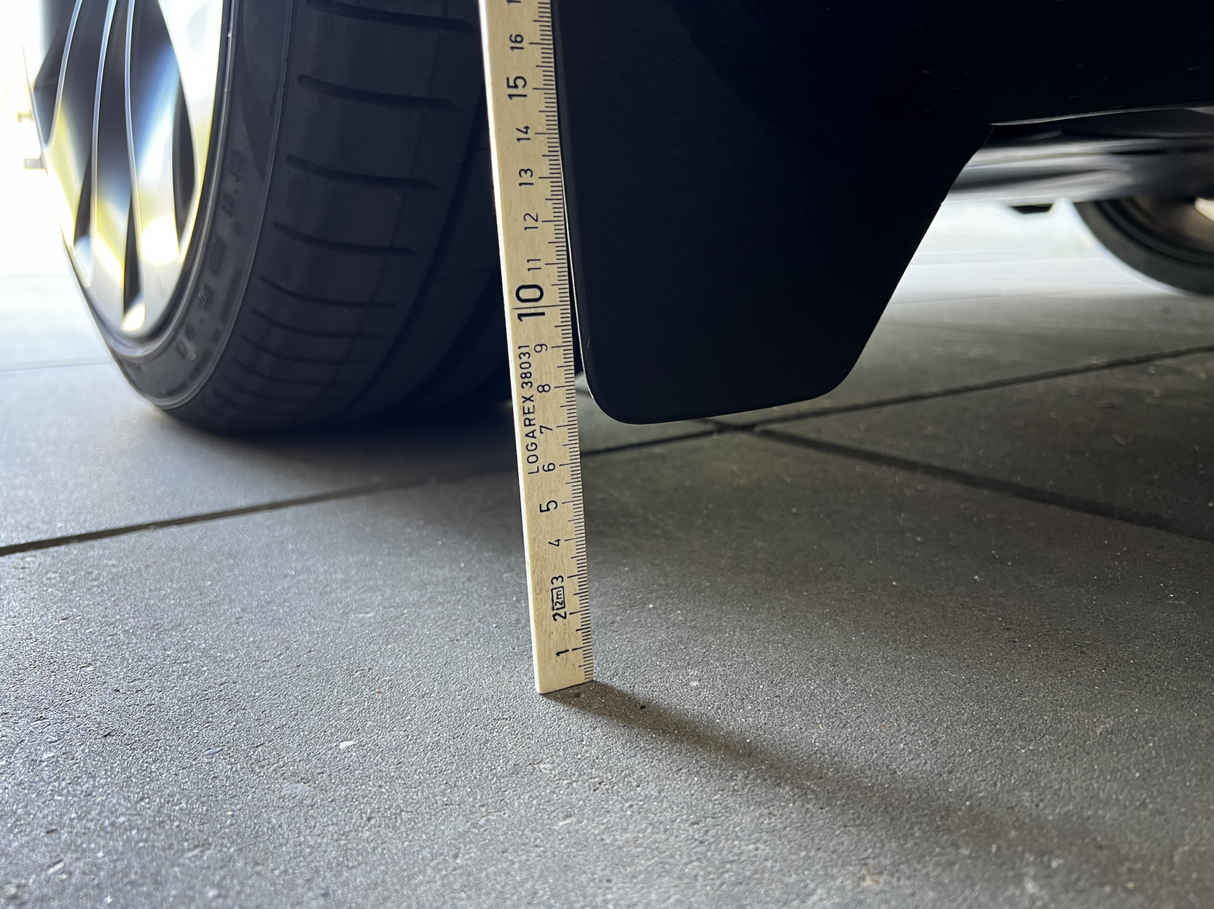 Originale stænklapper på Tesla Model Y målt med lineal.