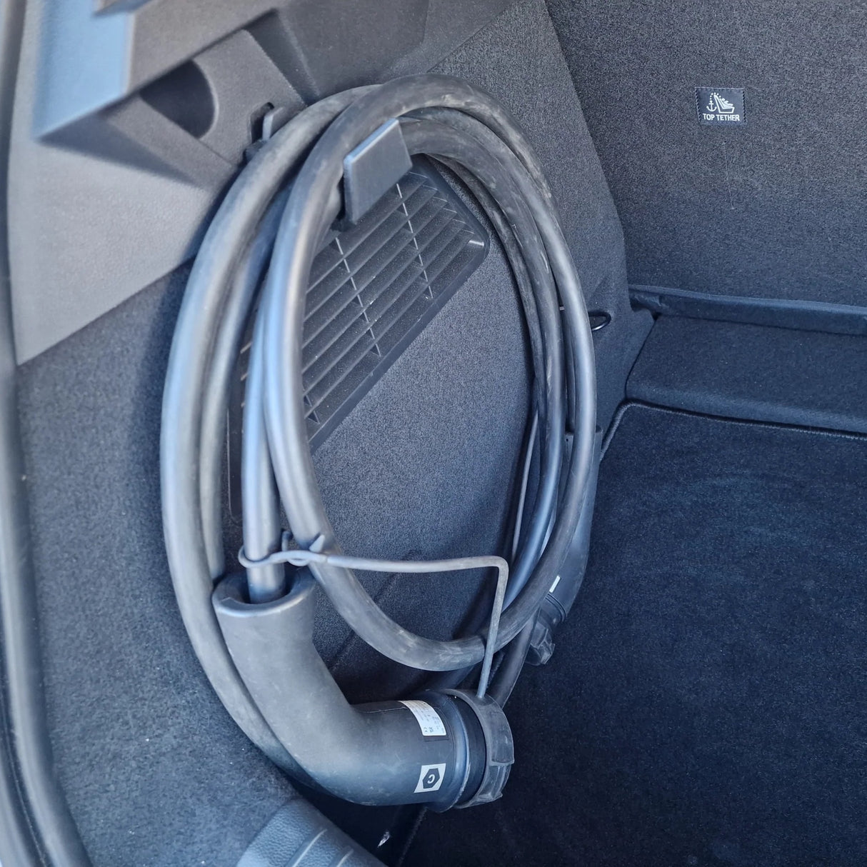 Sammenrullet ladekabel hængt op på bagagerumskrog i Renault Megane E-tech