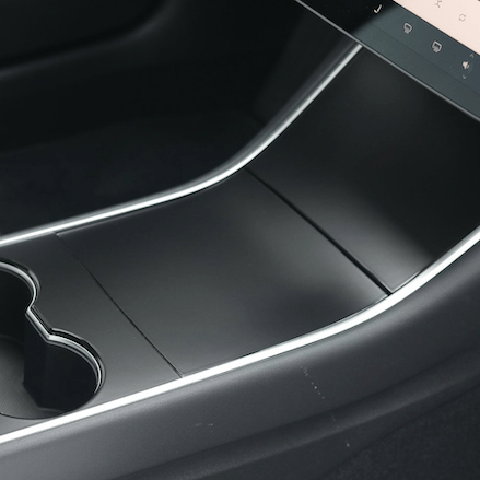 Mat sort cover monteret på midterkonsollen i en Tesla Model 3 før facelift