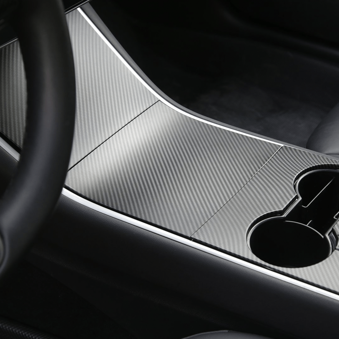 Cover i sølv carbon-look monteret på midterkonsollen i en Tesla Model 3 før facelift