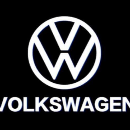 Hvidt VW-logo med teksten Volkswagen projiceret af LED-logolys på mørk baggrund