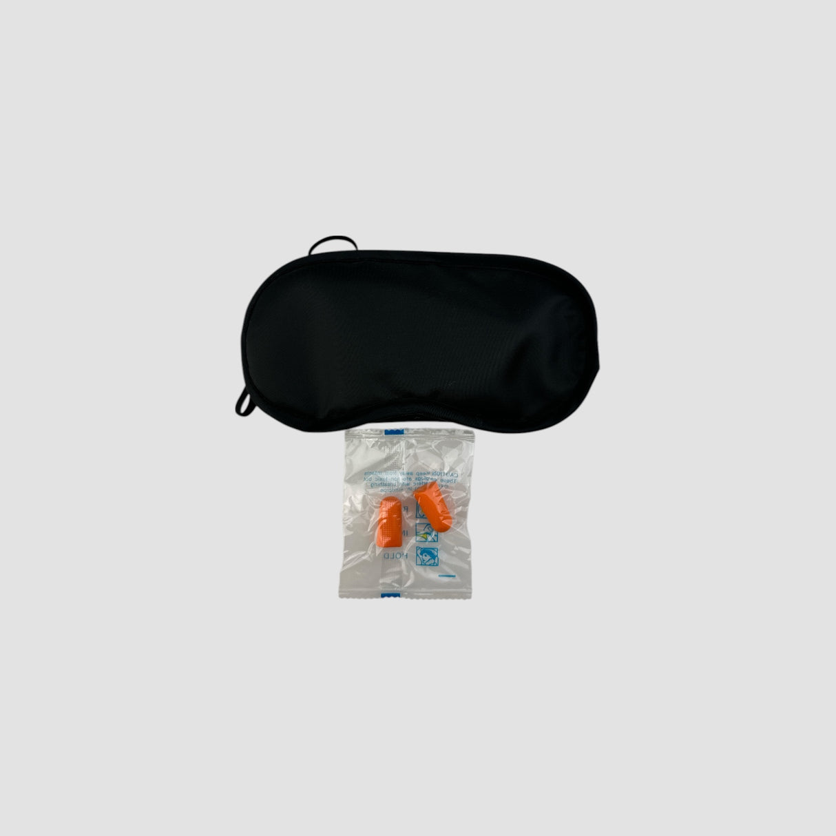Sort sovemaske med et par orange ørepropper i pose, produktbillede
