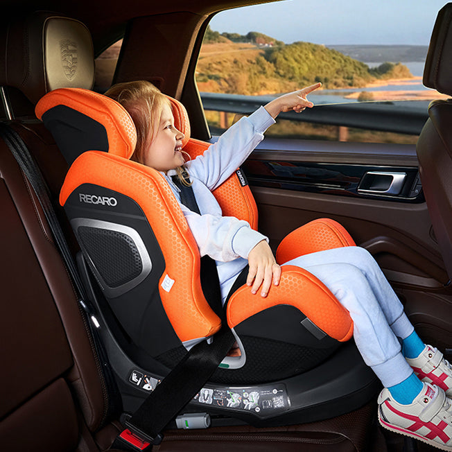 Barn peger ud af vinduet, fastspændt i Recaro Xenon 1 Kid autostol i bilen