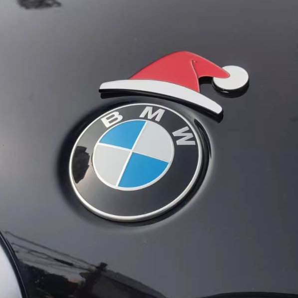 Rød og hvid nissehue monteret på BMW-emblem på bilens kølerhætte