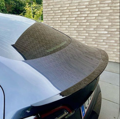 ABS-spoiler med carbon-look coating monteret på bagklappen af en sort Tesla Model Y, udendørs