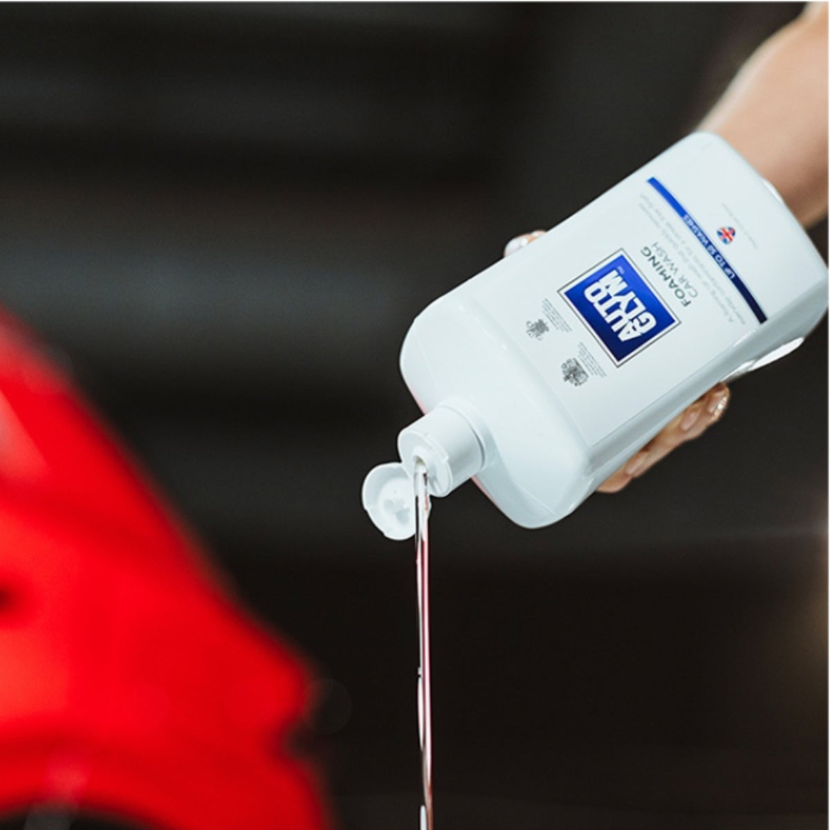 Hånd hælder Autoglym Foaming Car Wash Shampoo ud af flasken
