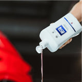 Hånd hælder Autoglym Foaming Car Wash Shampoo ud af flasken