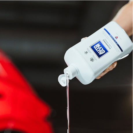 Hånd hælder Autoglym Foaming Car Wash Shampoo ud af flasken