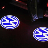 To blå VW LED logo-lys projiceret på jorden ved en bils åbne døre om natten