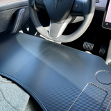 Foldbart bord i mørkt carbon-look, set inde i en Tesla bil