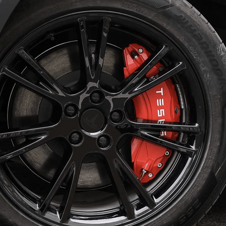 Rødt cover til bremsekaliber med TESLA-tekst monteret bag fælgen på en Tesla Model 3