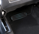 Sort gitter-cover til ventilationskanalen monteret under bagsædet i en Tesla Model Y