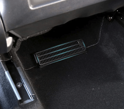 Sort gitter-cover til ventilationskanalen monteret under bagsædet i en Tesla Model Y