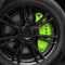Grønt cover til bremsekaliber med TESLA-tekst monteret bag fælgen på en Tesla Model Y