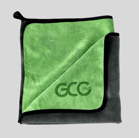 GCG MAX mikrofiberklud i grøn og mørkegrå, foldet og med logo.