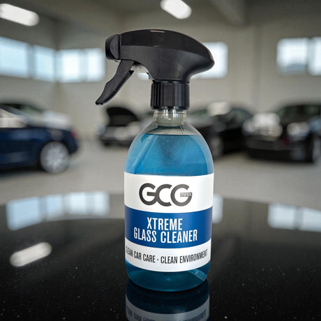 GCG MAX Xtreme Glass Cleaner spray i blå flaske på bord med biler i baggrunden