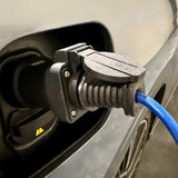 Hånd, der indsætter eller fjerner GCG Max V2L adapter i bilens ladeport