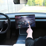Hånd der spiller et spil på den drejede Tesla-skærm med drejebeslag
