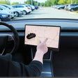 Hånd der drejer Tesla-skærmen med drejebeslag monteret, set fra førerplads