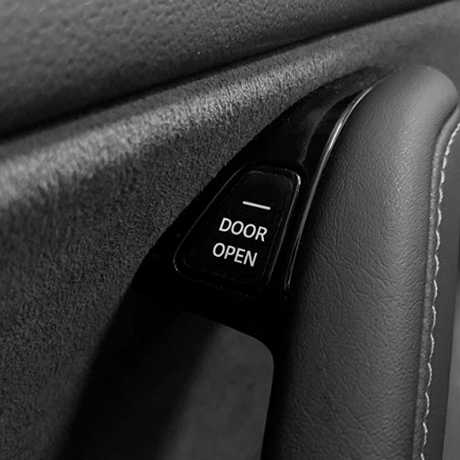 Dørknap med klistermærke med teksten Door Open på dørpanelet i en Tesla