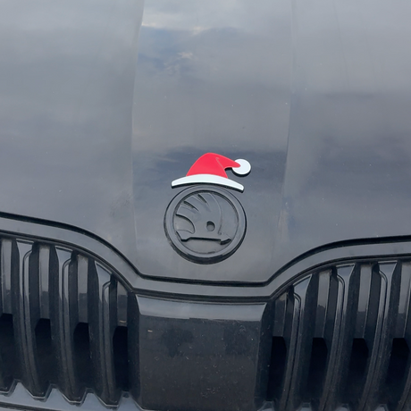Rød og hvid nissehue monteret på Skoda-emblem foran på bilens kølergrill