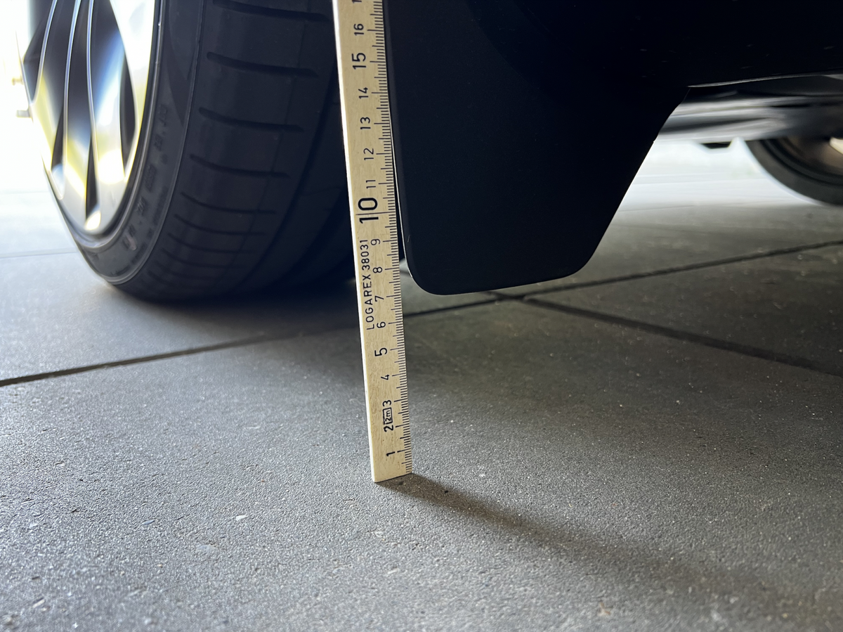 Originale stænklapper på Tesla Model Y målt med lineal.
