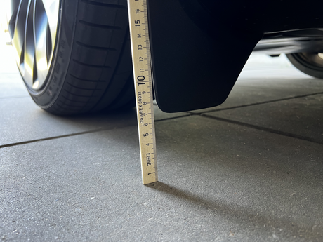 Originale stænklapper på Tesla Model Y målt med lineal.