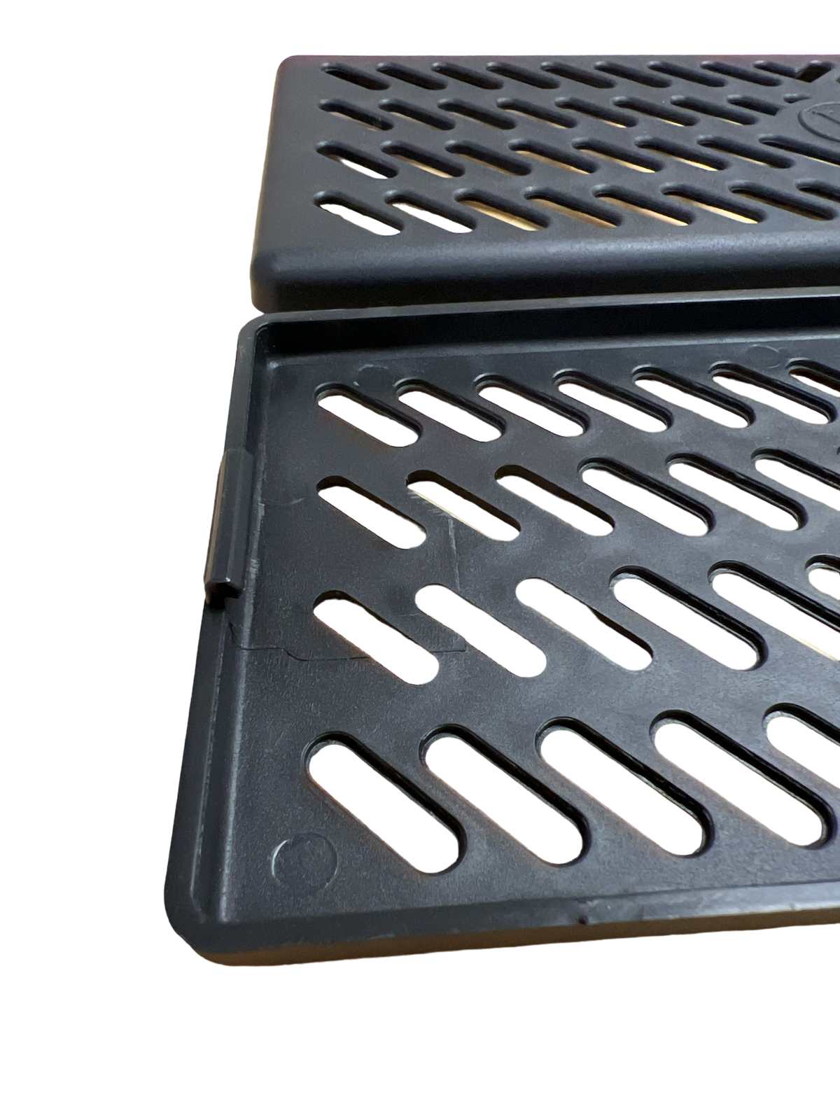 Nærbillede af de to sorte gitter-covers til ventilationskanalen på gennemsigtig baggrund