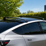 Sorte tagbøjler monteret på taget af en sølvfarvet Tesla Model 3/Y, udendørs