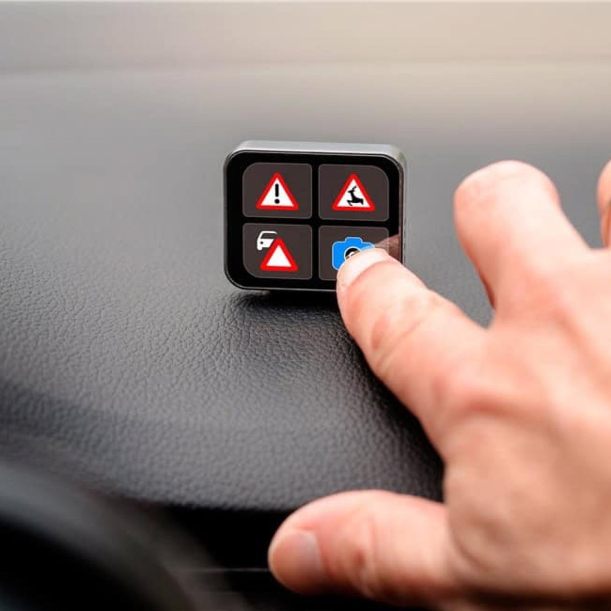 Finger trykker på advarselsknap på Saphe T trafikalarm med fire faresymboler