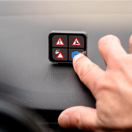 Finger trykker på advarselsknap på Saphe T trafikalarm med fire faresymboler