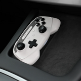 Hvid trådløs controller placeret i Teslaens trådløse opladerbakke i centerkonsollen