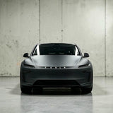 Tesla Model Y 2025 Juniper set forfra i mat grå, viser TESLA logo på lystribe