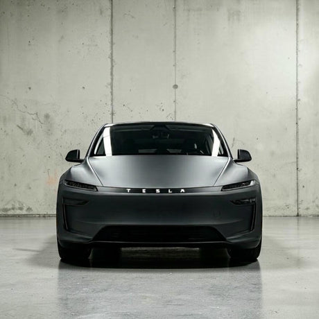 Tesla Model Y 2025 Juniper set forfra i mat grå, viser TESLA logo på lystribe