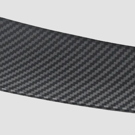 Nærbillede af Tesla Model Y-spoiler i mat carbon-look finish på lys baggrund