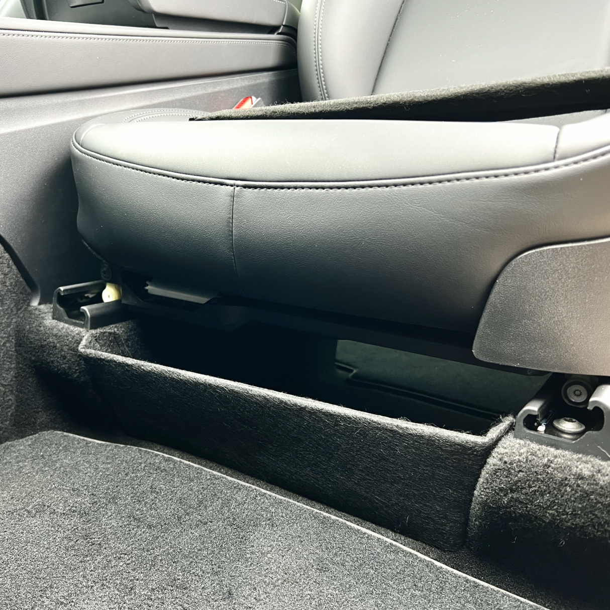 Deler til oppbevaring under setet til Tesla Model Y