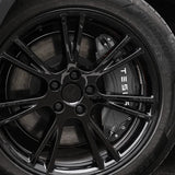 Sort cover til bremsekaliber med TESLA-tekst monteret bag fælgen på en Tesla Model Y