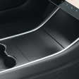 Mat sort cover monteret på midterkonsollen i en Tesla Model 3 før facelift
