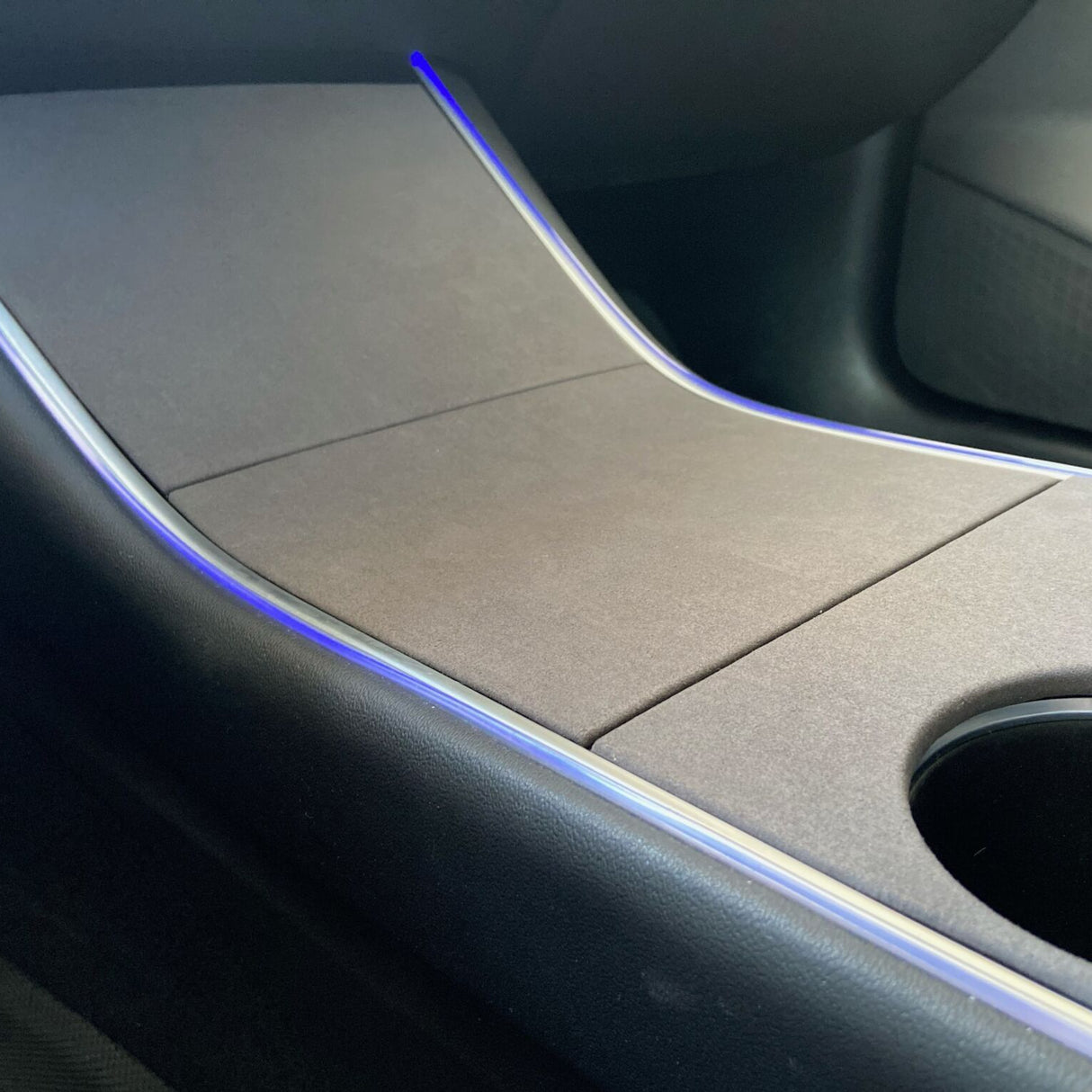 Cover i mørk mat finish monteret på midterkonsollen i en Tesla Model 3 før facelift