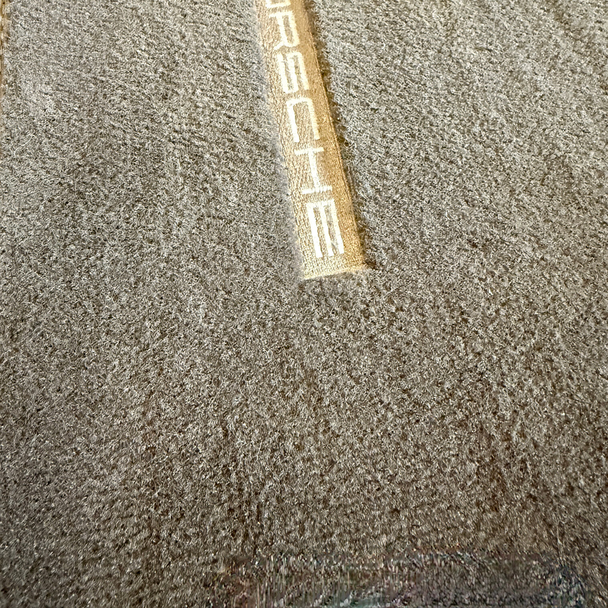 Efterbillede af ren bilmåtte med Porsche logo efter brug af støvsugeren