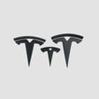 Tre Tesla T-emblem covers i mat sort i forskellige størrelser til Model 3