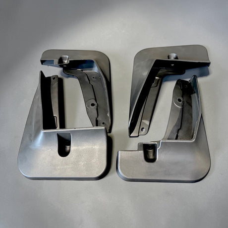 Sæt af to sølvfarvede mudflaps/stænklapper til Zeekr X, set fra oven på grå baggrund